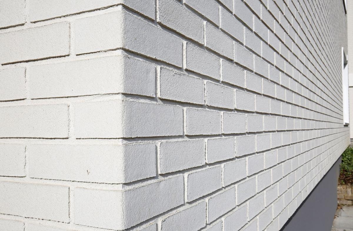 Architekti navrhli obkladové pásiky StoCleye B v podobne bielej tehly, ako cenovo dostupné riešenie fasády bytového domu.
